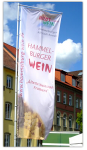 Werbebanner als Fahne mit Digitaldruck auf Fahnenstoff. Hier sehen Sie eine Fahne für "Hammelburger Wein" mit dem Top-Seller "Event-Teleskopmast" aus unserem Angebot.